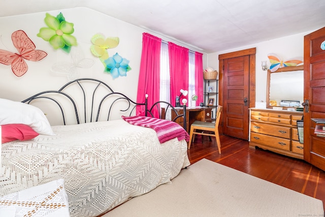 bedroom featuring wood finished floors and lofted ceiling