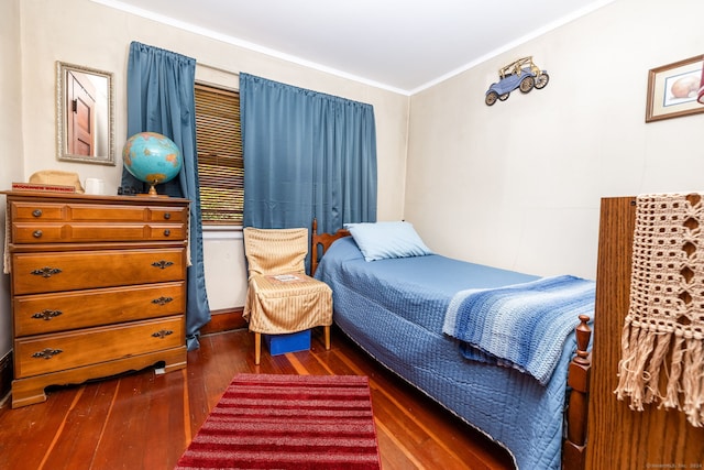bedroom featuring dark wood-type flooring and crown molding