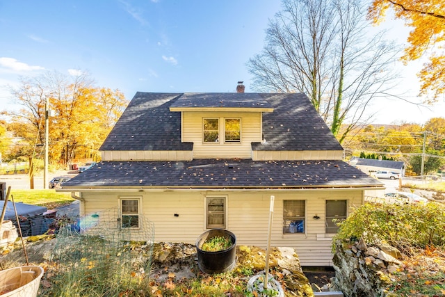 rear view of house featuring a chimney