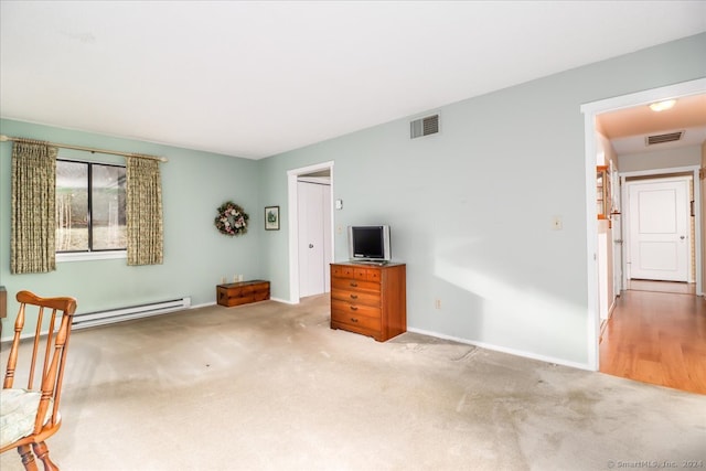 unfurnished living room featuring a baseboard heating unit and light colored carpet