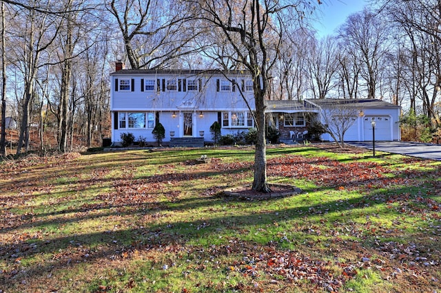 colonial-style house featuring a front lawn and a garage