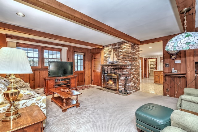 carpeted living room featuring beam ceiling, a brick fireplace, and wood walls