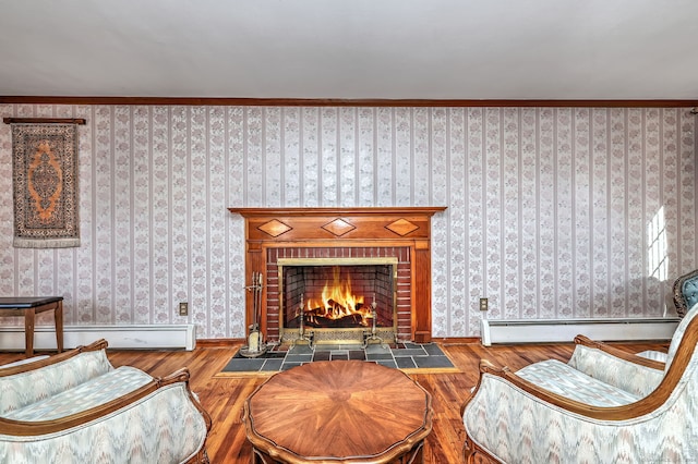 living area featuring a fireplace, hardwood / wood-style flooring, baseboard heating, and ornamental molding