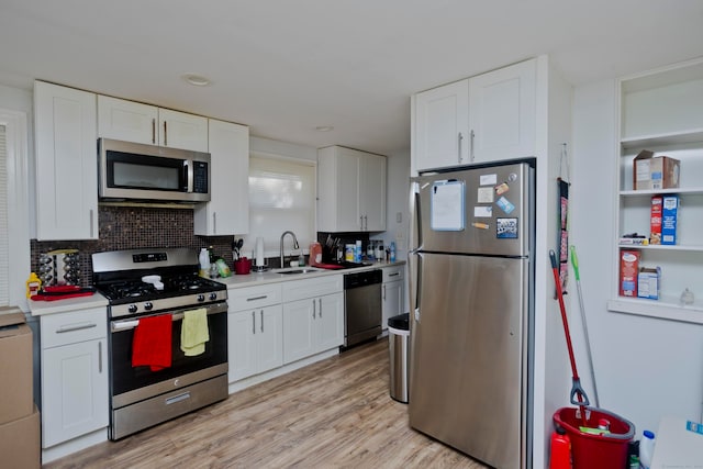 kitchen with white cabinetry, stainless steel appliances, and light wood-type flooring