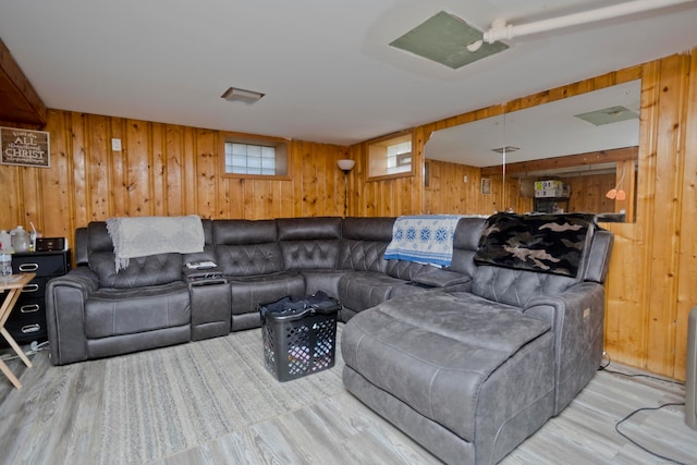 living room with light hardwood / wood-style flooring and wooden walls