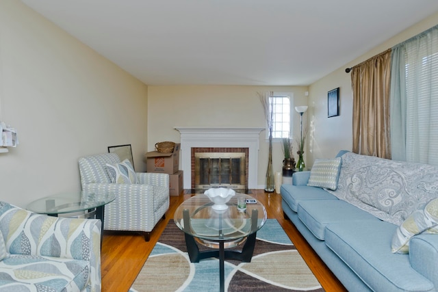 living room featuring hardwood / wood-style floors and a brick fireplace