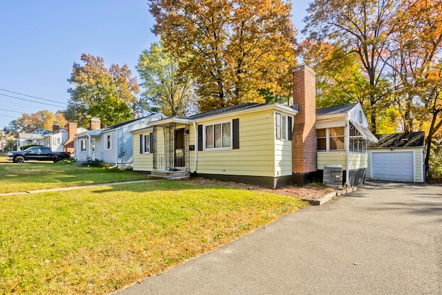 view of front of property with central air condition unit, a front yard, and a garage