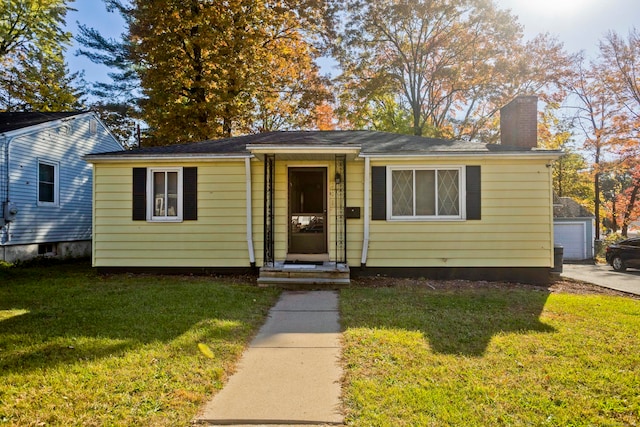 view of front facade with a garage, a front lawn, and an outdoor structure