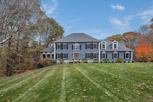 colonial home featuring a front lawn