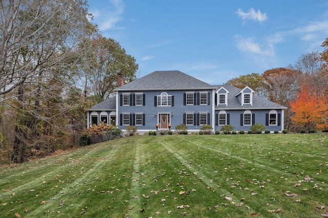 view of front of property with a front yard and a shingled roof