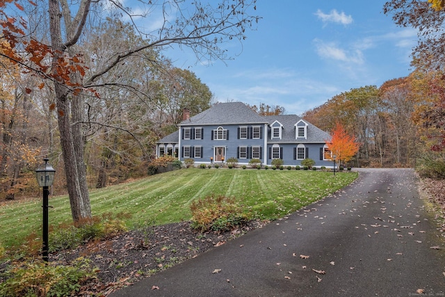 view of front of house featuring a chimney and a front yard