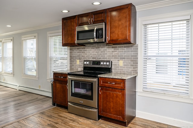 kitchen featuring baseboard heating, light hardwood / wood-style flooring, stainless steel appliances, ornamental molding, and light stone countertops