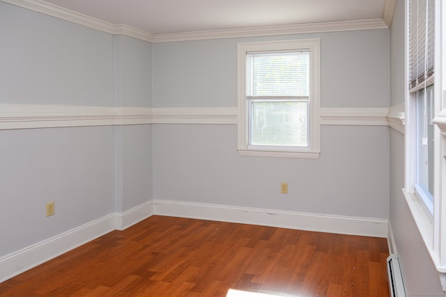 spare room featuring crown molding, hardwood / wood-style flooring, and a baseboard heating unit