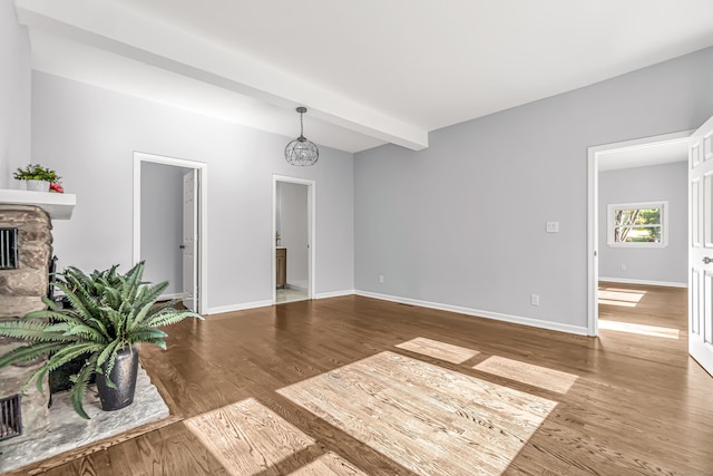 interior space featuring beamed ceiling, a chandelier, a fireplace, and hardwood / wood-style floors