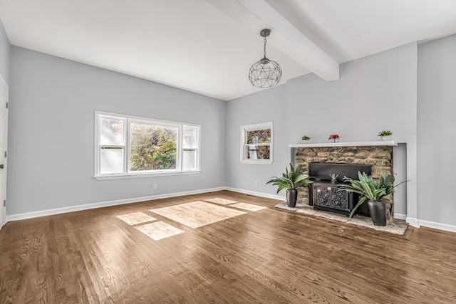 living room with hardwood / wood-style floors, beamed ceiling, and a fireplace