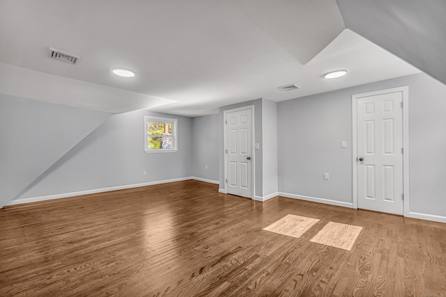 additional living space with lofted ceiling and hardwood / wood-style floors