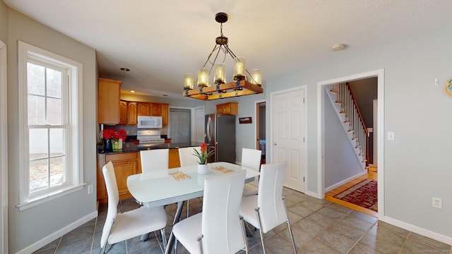 dining area with tile patterned floors and a notable chandelier