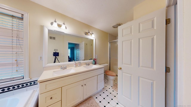 full bathroom featuring separate shower and tub, vanity, a textured ceiling, and plenty of natural light