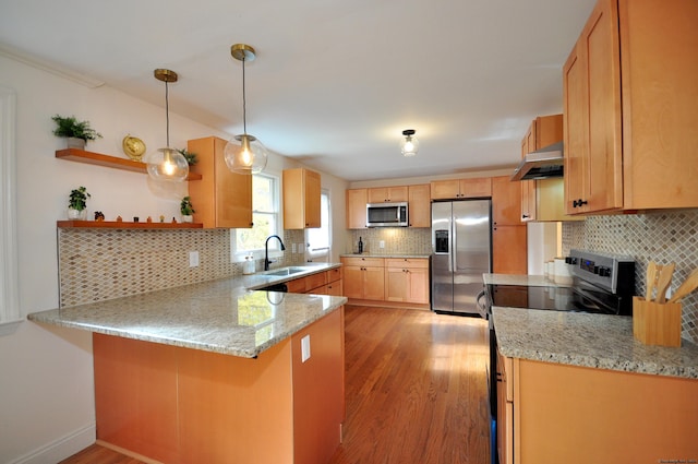 kitchen featuring sink, kitchen peninsula, light hardwood / wood-style floors, decorative light fixtures, and appliances with stainless steel finishes