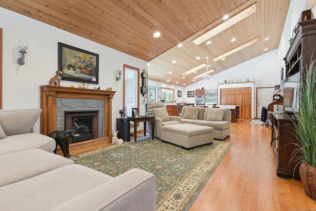 living room with high vaulted ceiling, recessed lighting, a skylight, light wood finished floors, and wood ceiling