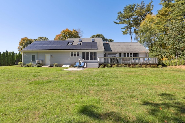 back of house featuring a wooden deck, a yard, solar panels, and a sunroom