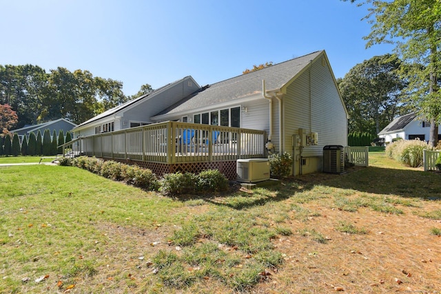 rear view of property featuring central air condition unit, a yard, and a wooden deck