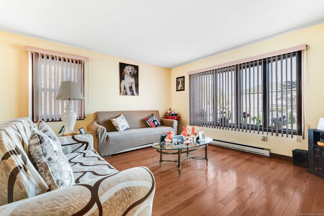 living room featuring plenty of natural light, wood-type flooring, and baseboard heating