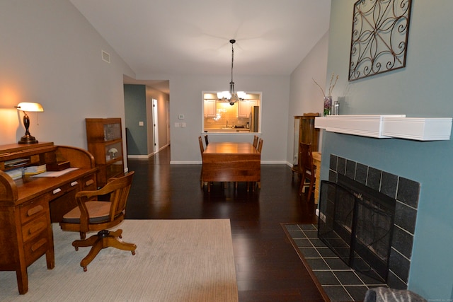 office space with a tiled fireplace, dark hardwood / wood-style flooring, and an inviting chandelier