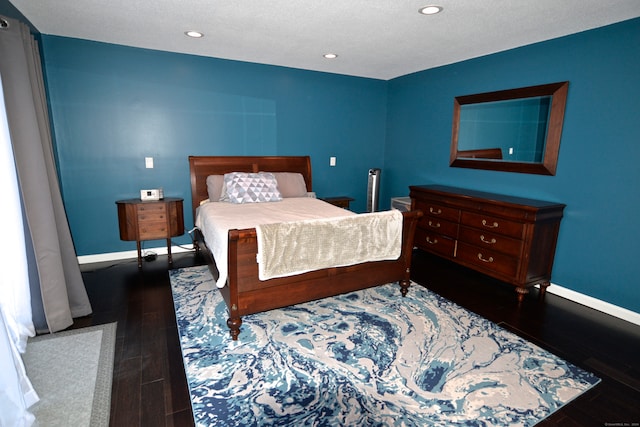 bedroom with a textured ceiling and dark wood-type flooring