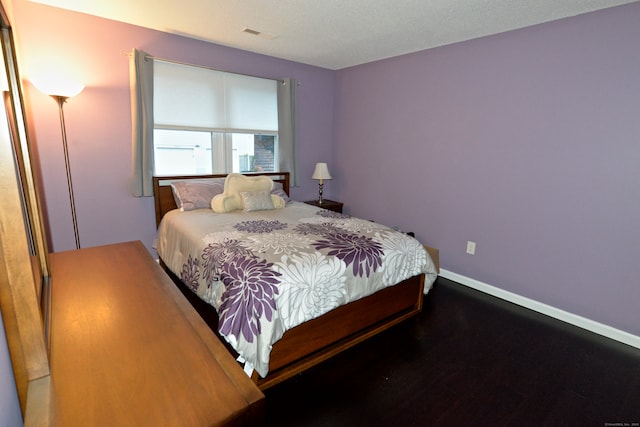 bedroom with hardwood / wood-style floors and a textured ceiling