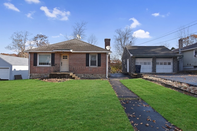 view of front of home with an outbuilding, a front lawn, and a garage