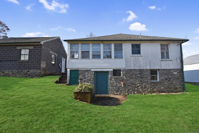 rear view of house featuring a lawn