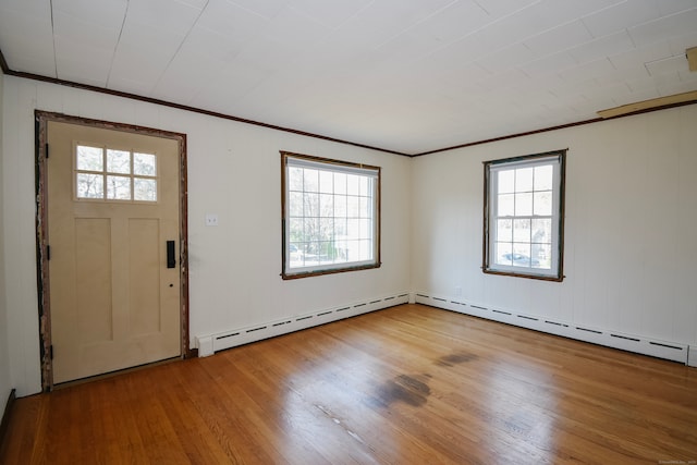 foyer with a baseboard heating unit, a wealth of natural light, and hardwood / wood-style floors