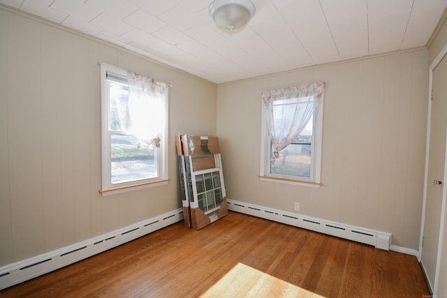 spare room featuring a baseboard radiator and light wood-type flooring