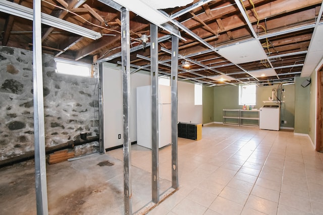 basement with washer / clothes dryer and stainless steel fridge