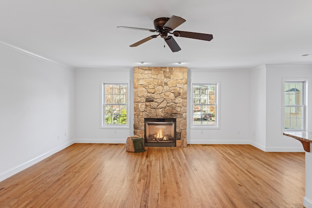 unfurnished living room with a fireplace, ceiling fan, light hardwood / wood-style flooring, and crown molding