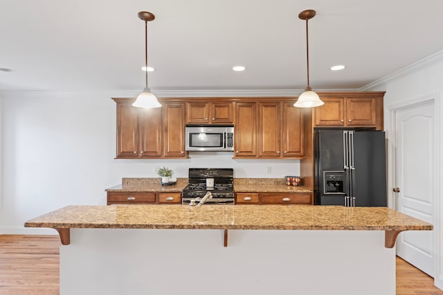 kitchen with a kitchen island with sink, a kitchen bar, black appliances, and light hardwood / wood-style flooring