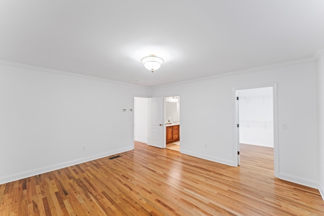 unfurnished room featuring ornamental molding and light hardwood / wood-style floors