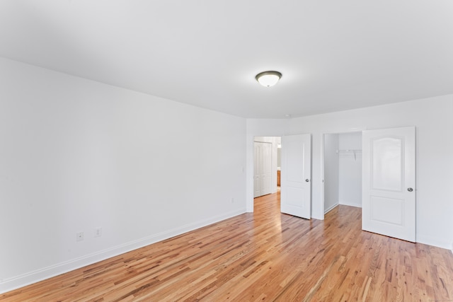 unfurnished bedroom featuring light hardwood / wood-style flooring and a closet