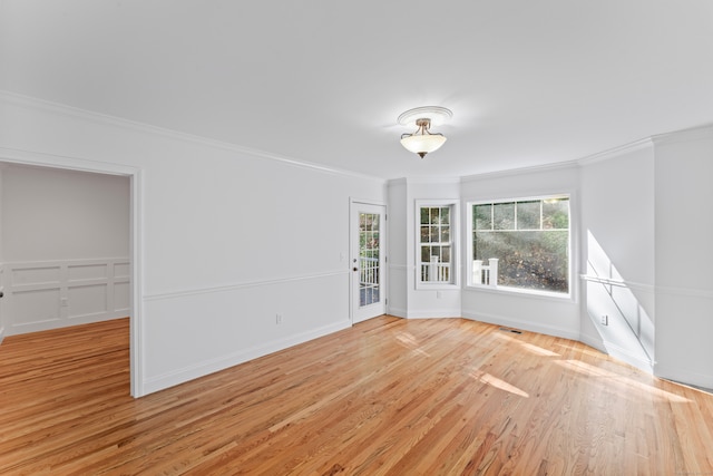 unfurnished room with light hardwood / wood-style flooring and ornamental molding