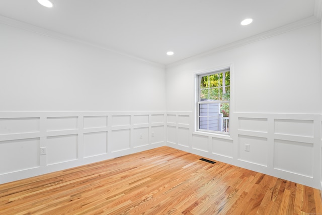 empty room featuring light hardwood / wood-style floors and crown molding