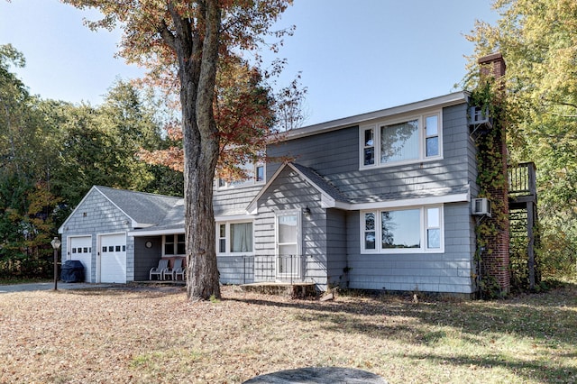 front of property with a porch, a garage, an AC wall unit, and a front yard