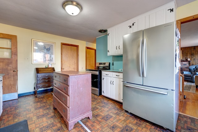 kitchen with white cabinets, a center island, wood walls, and stainless steel appliances