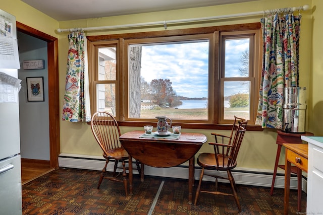 dining area with breakfast area, a water view, and a baseboard heating unit