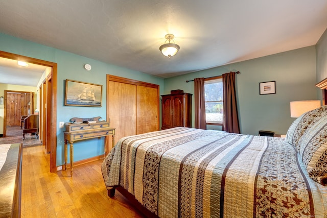 bedroom with light hardwood / wood-style floors and a closet