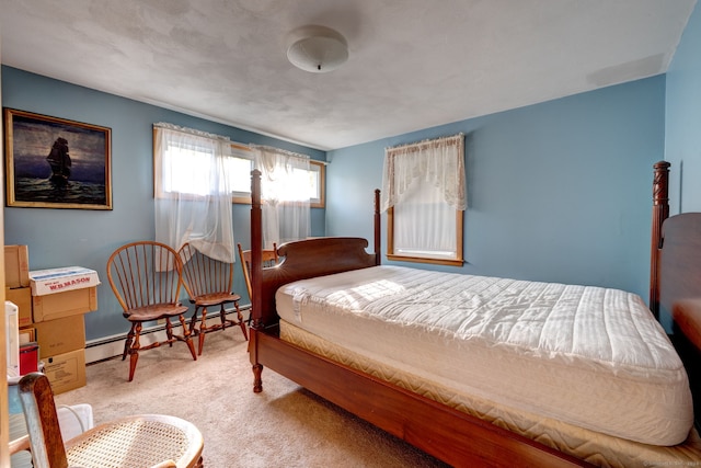 bedroom with baseboard heating and light carpet