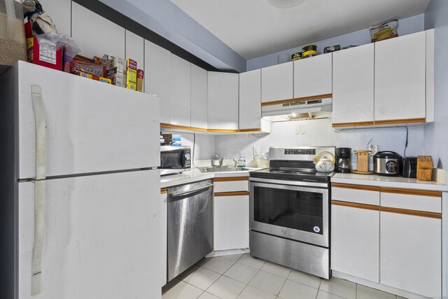 30 Merwin St Unit 6, Norwalk, CT 06850 - kitchen featuring appliances with stainless steel finishes, under cabinet range hood, light countertops, light tile patterned floors, and white cabinetry