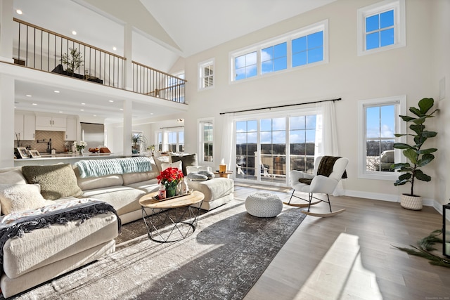 living room featuring light hardwood / wood-style flooring and high vaulted ceiling