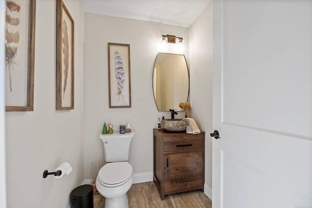 bathroom featuring wood-type flooring, vanity, and toilet