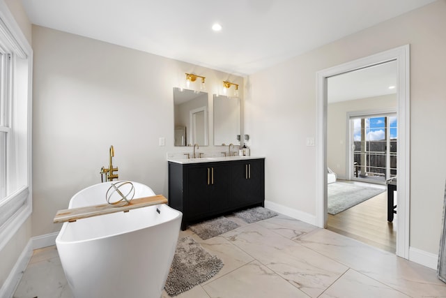 bathroom featuring a washtub and vanity